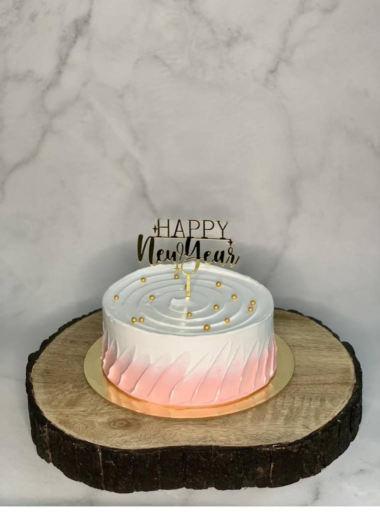 Pink ombre New Year cake on a wood slice