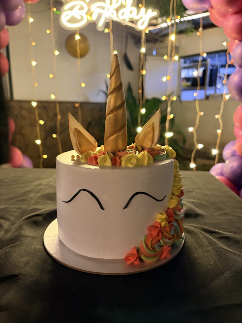 White unicorn cake with a gold horn and floral mane