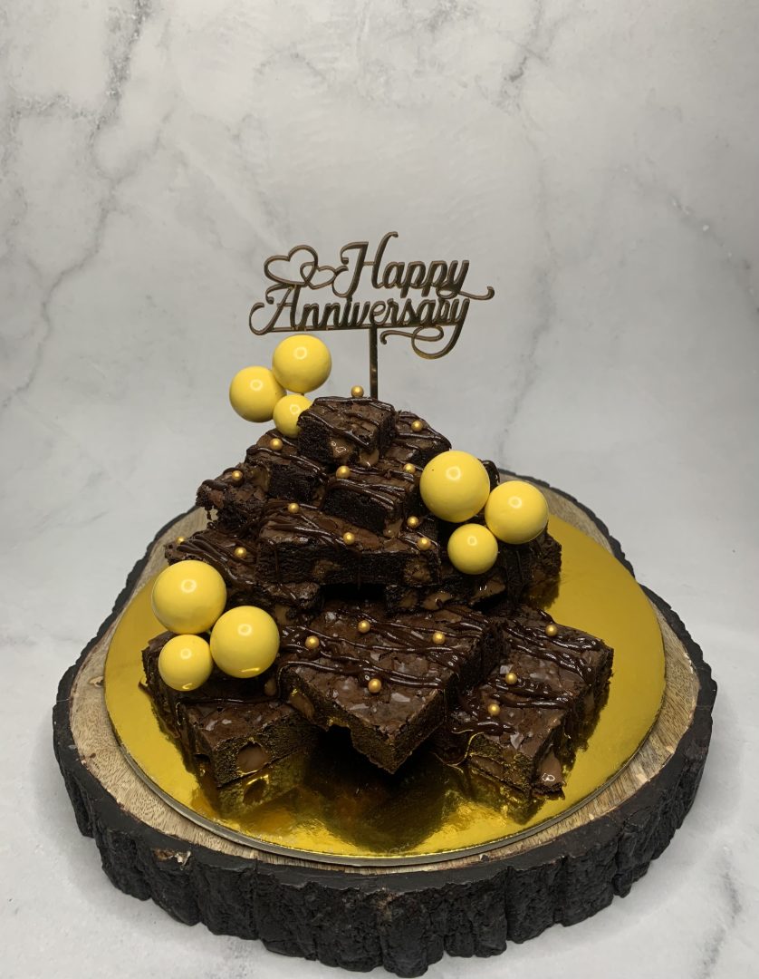 Stacked brownie tower with gold accents on a wood slice