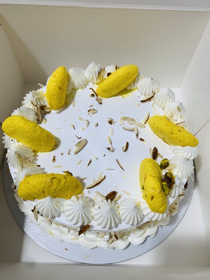 Rasamalai cream cake topped with saffron rasagulla and slivered nuts